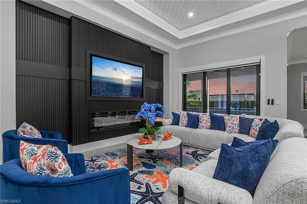 Living room with a black slatted feature wall holding a television and linear fireplace, beneath a planked tray ceiling.