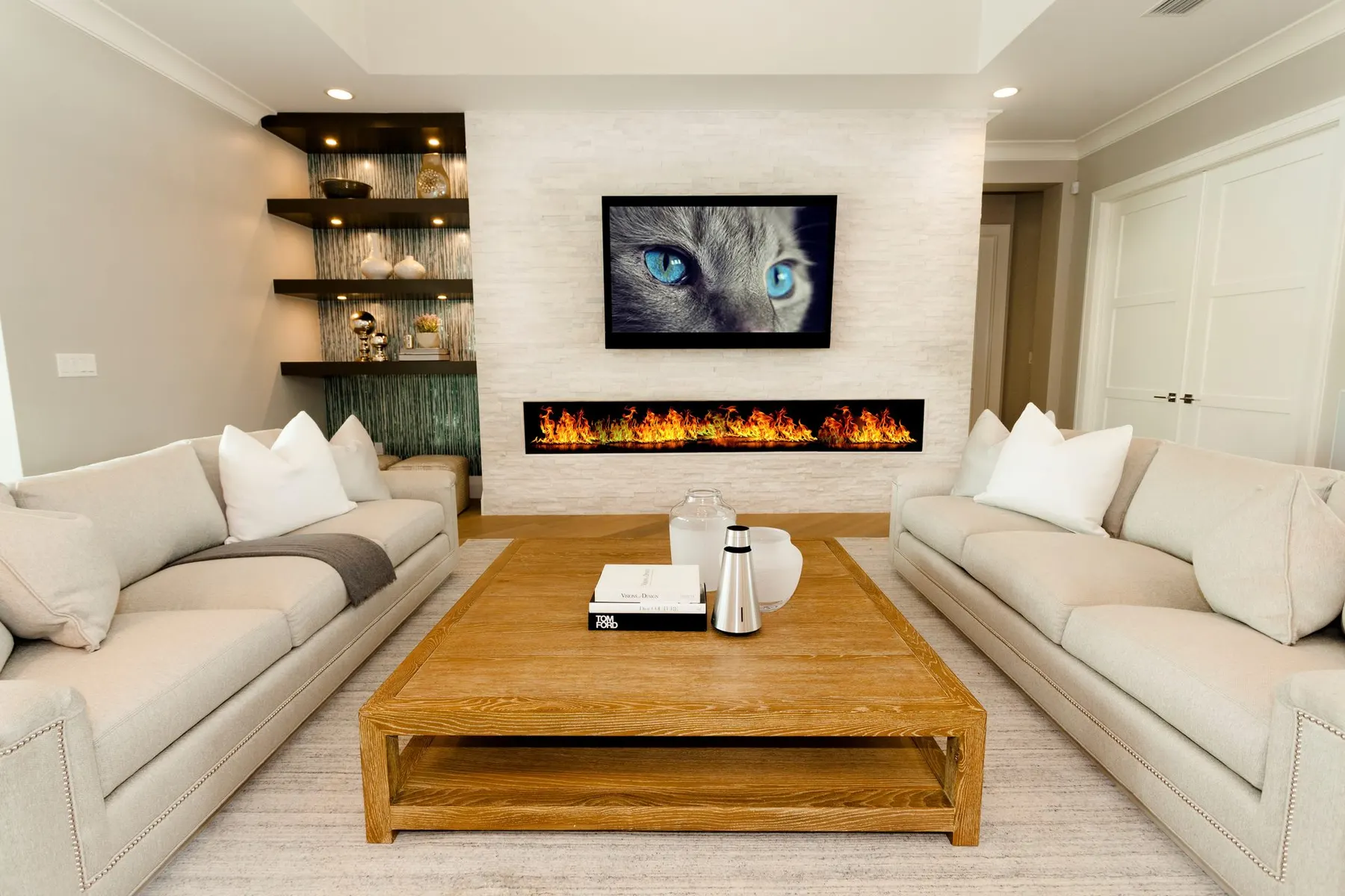 Family room with a linear fireplace, built-in shelving and a wood coffee table.