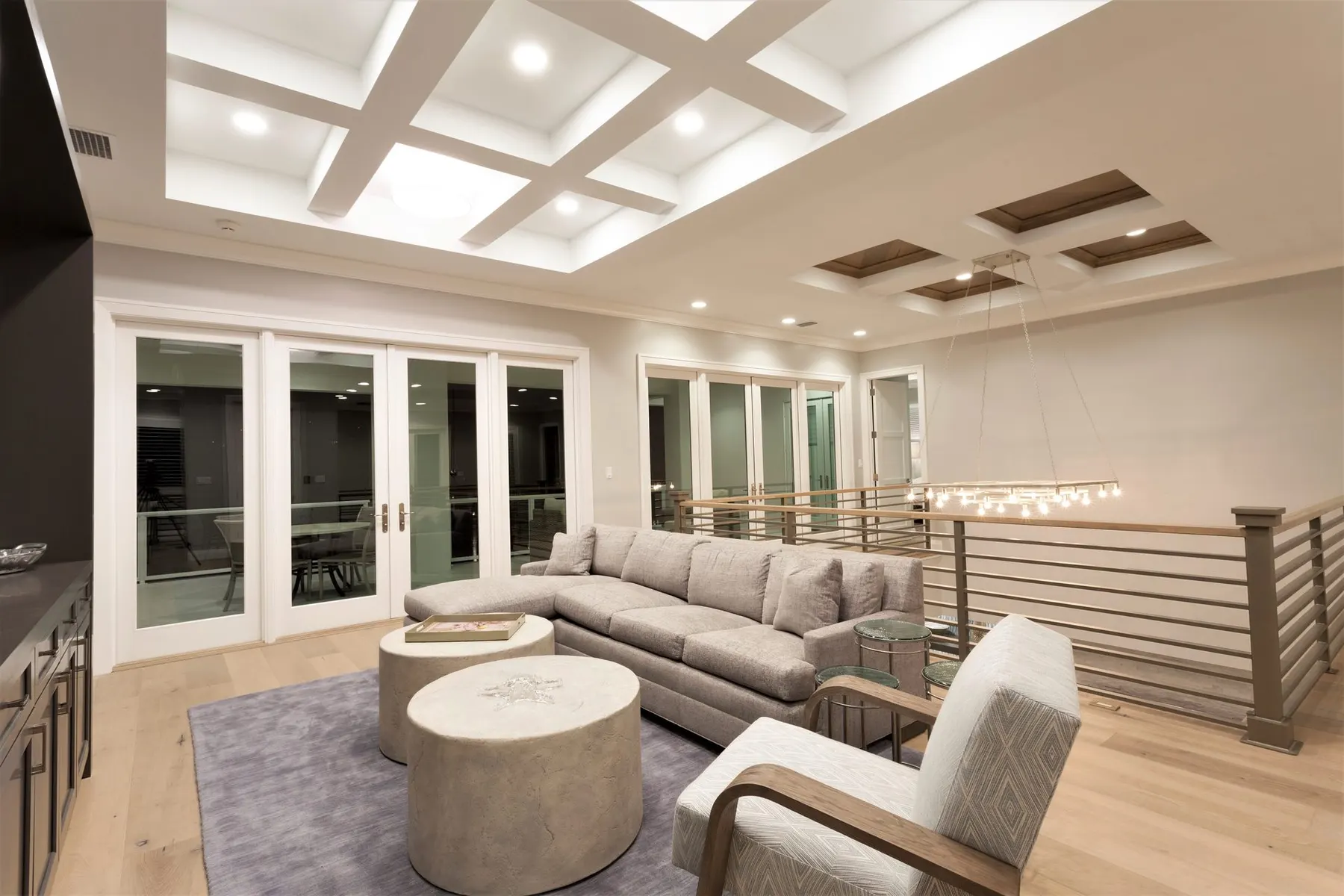 Living room with a coffered ceiling and glass doors to the balcony.