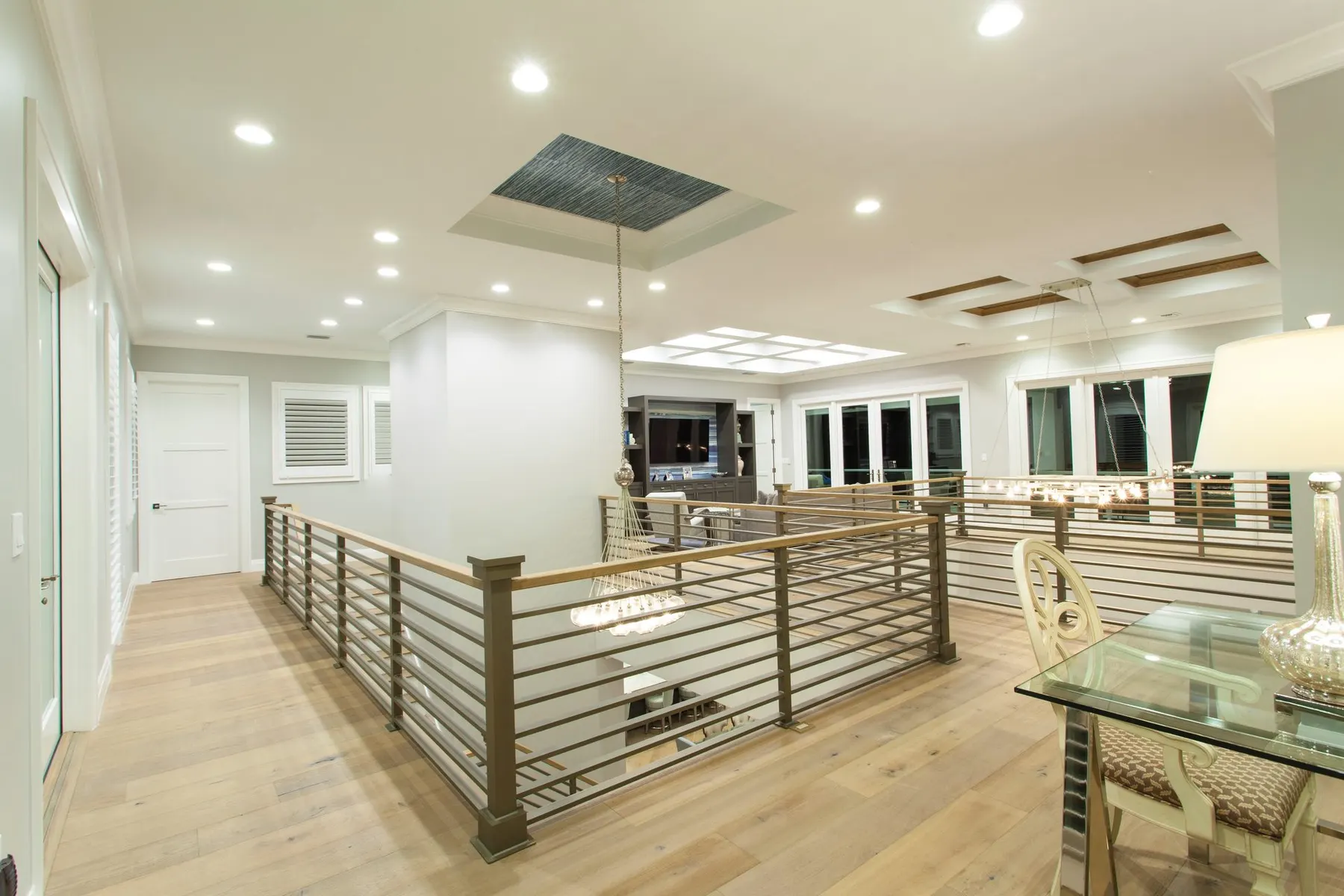 Upper-level loft with a horizontal railing and coffered ceiling.