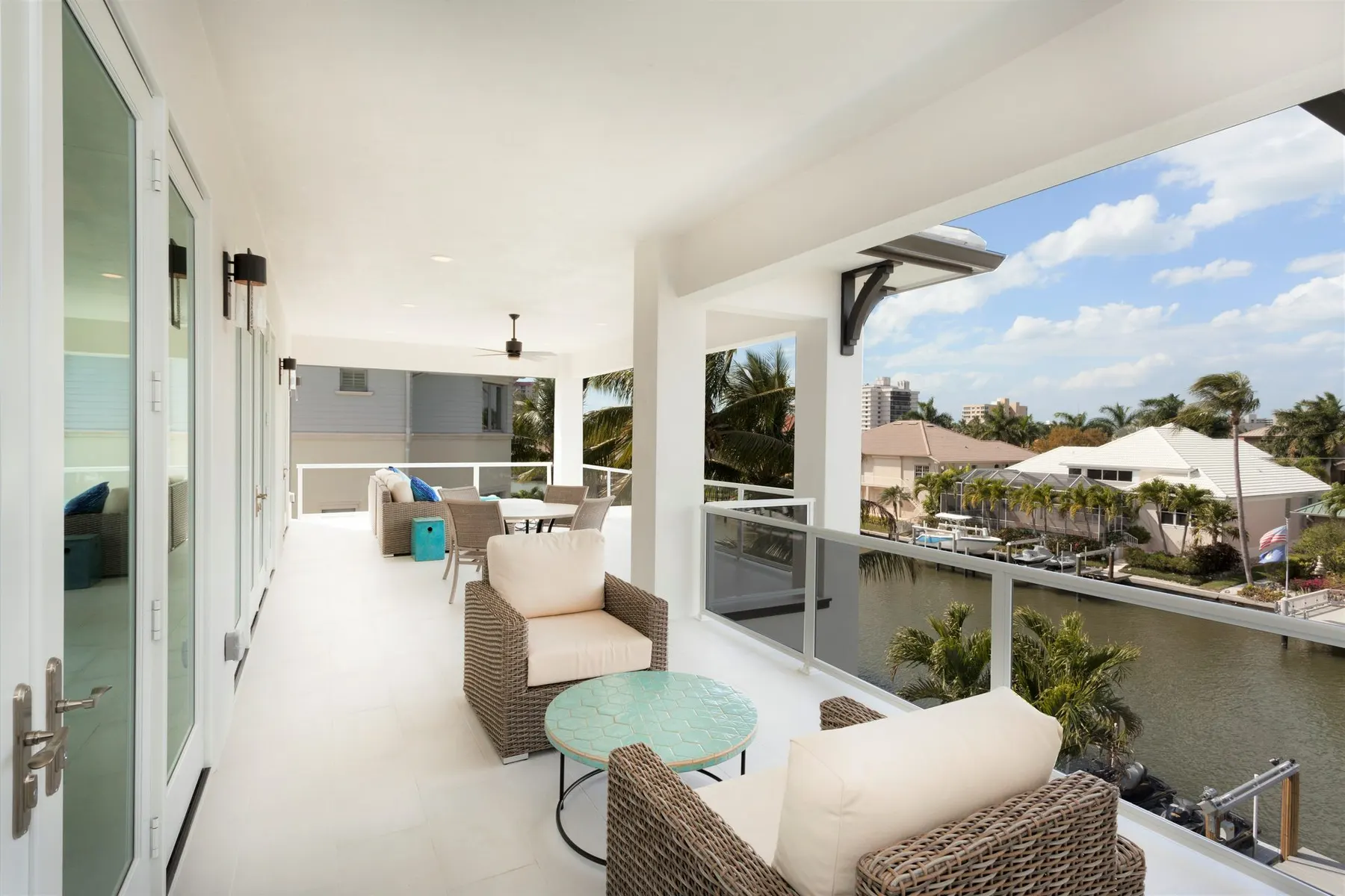 Covered balcony with a glass railing overlooking the canal.