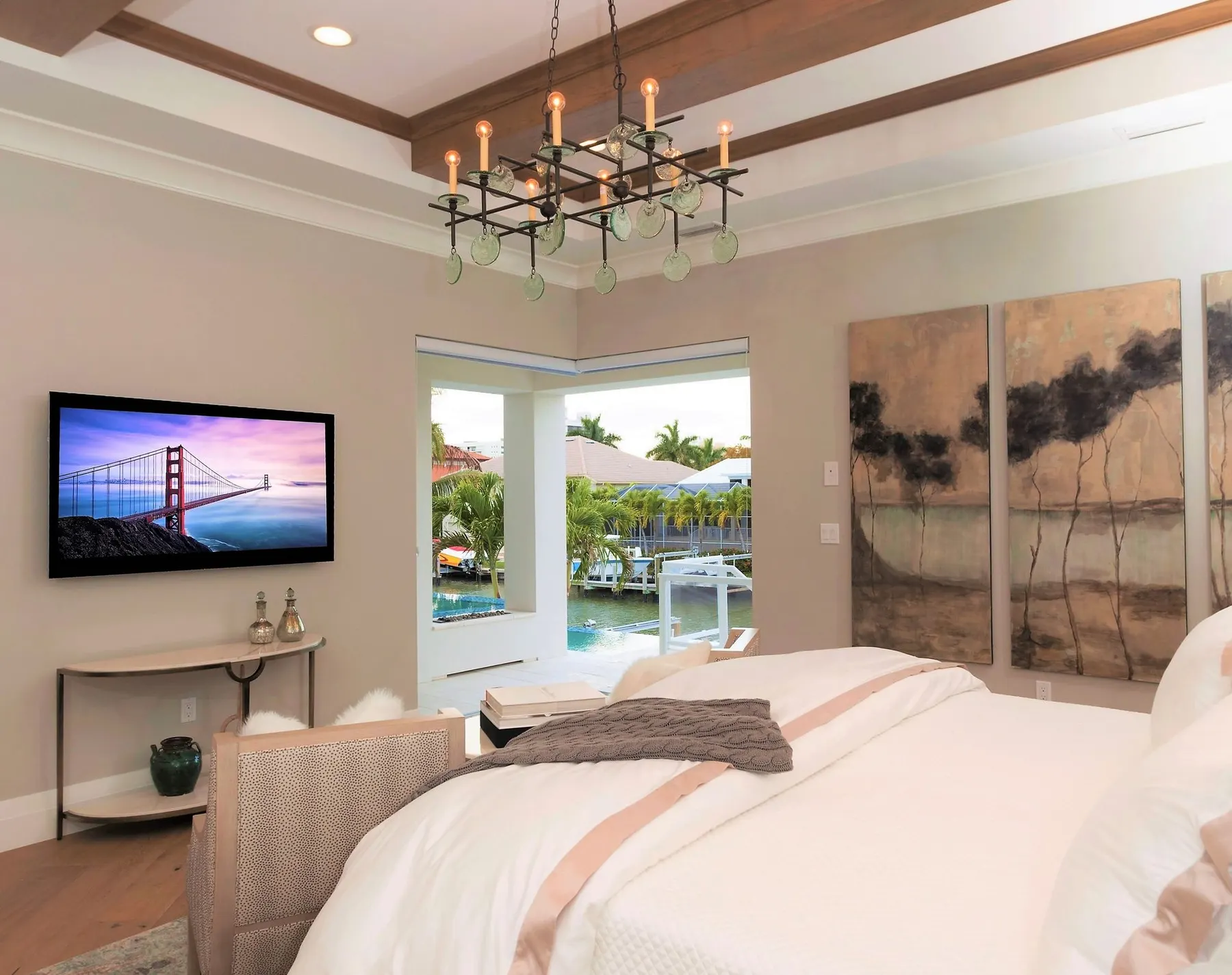 Bedroom with a beamed tray ceiling and a chandelier.