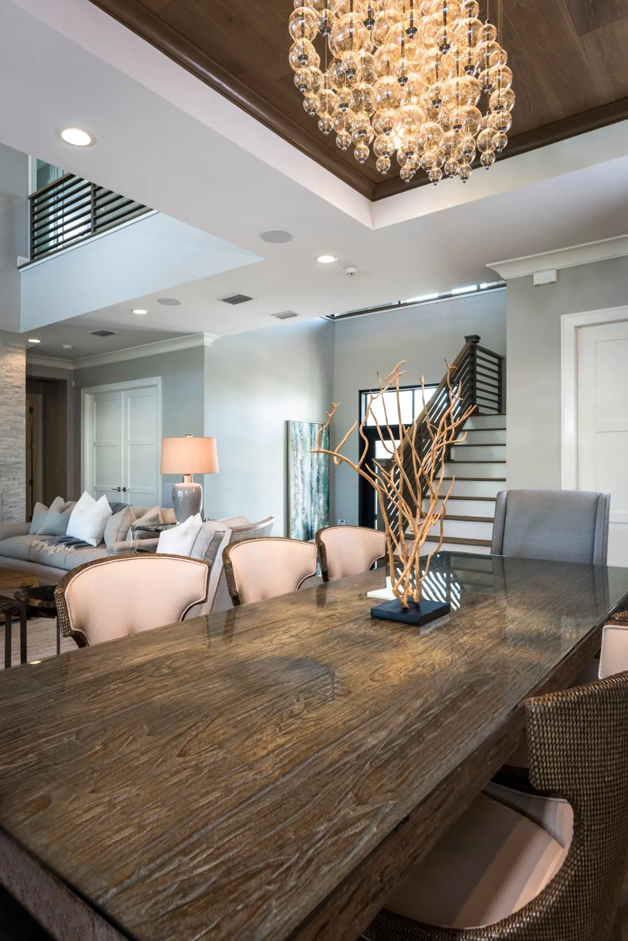 Dining room beneath a wood ceiling and shell chandelier, with the stair beyond.
