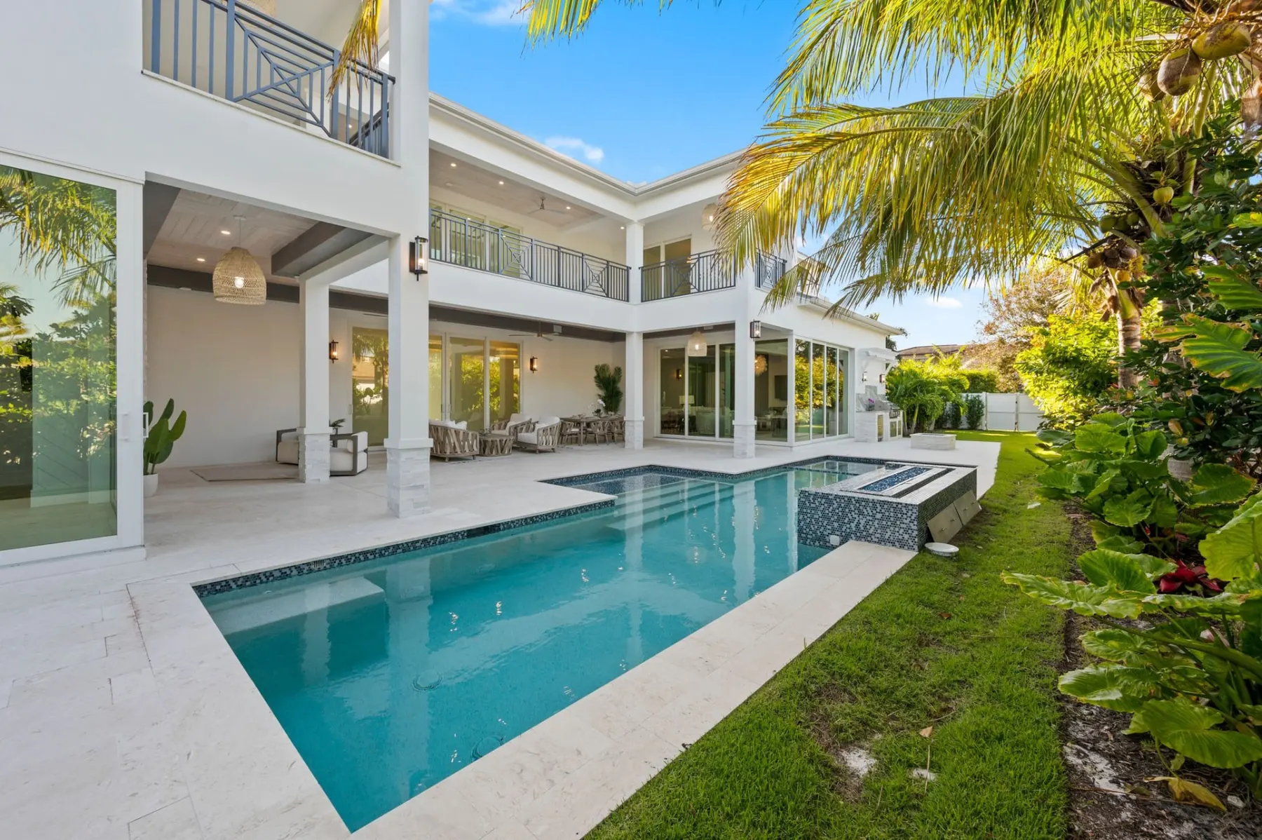 Pool and spa with a blue mosaic tile edge, seen with the rear balconies of the home.
