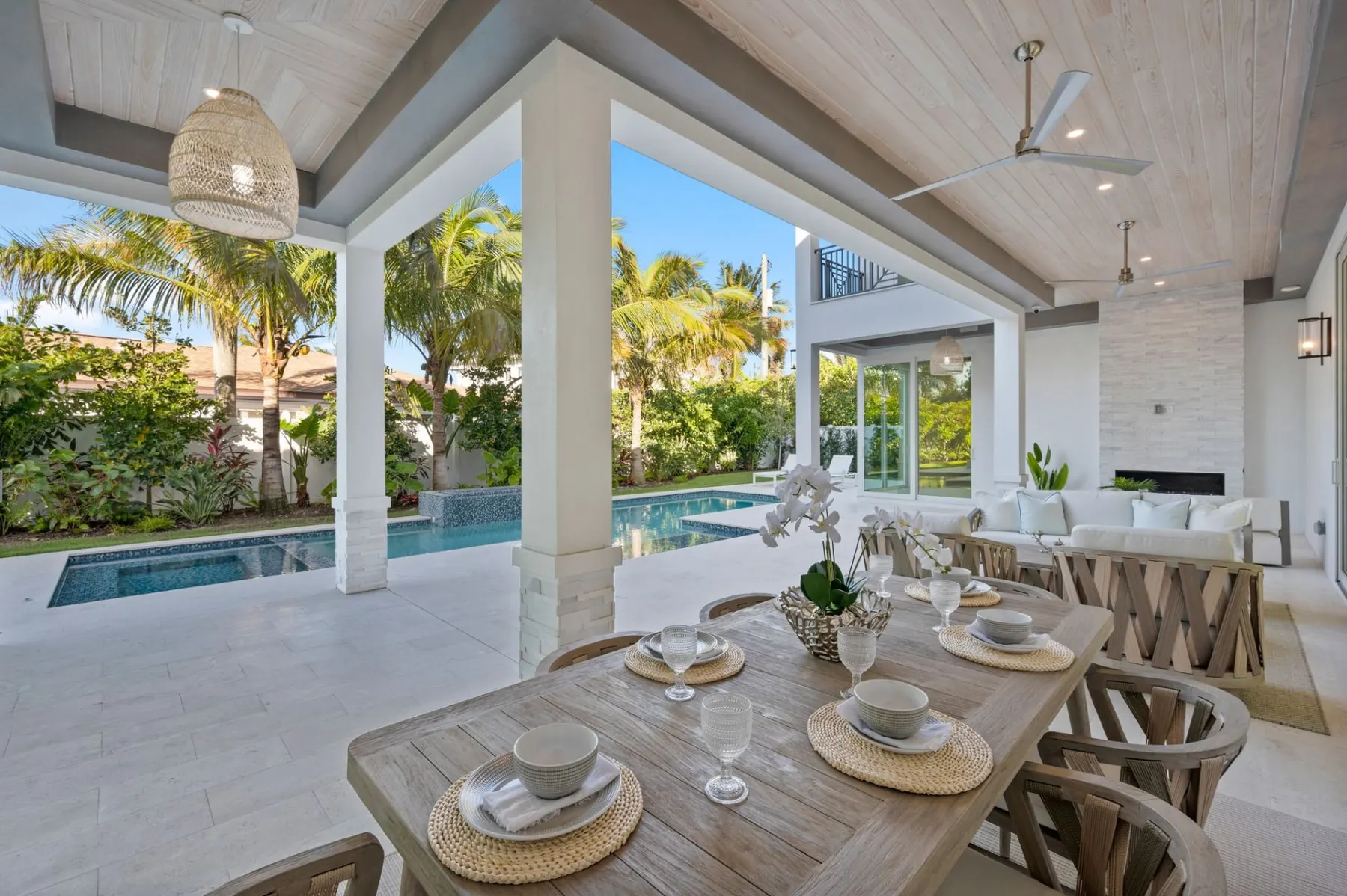 Lanai dining table under a wood-plank ceiling with the pool beyond.