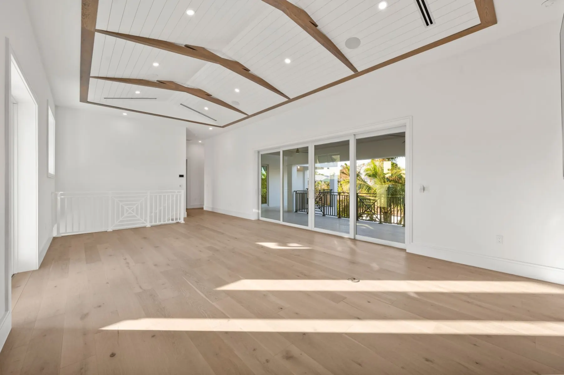 Upstairs lounge with wood floors and sliding glass doors to the balcony.