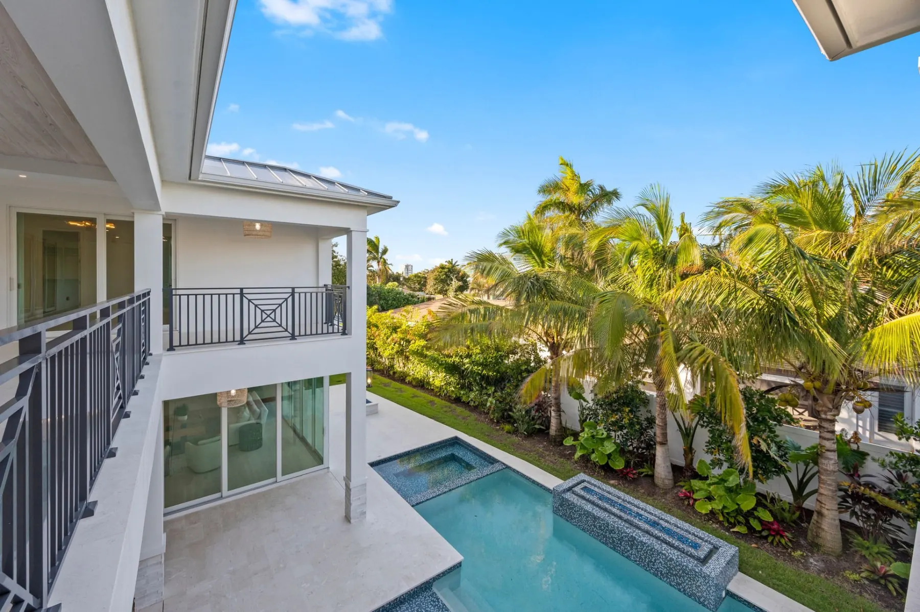 View from the upstairs balcony over the pool and spa, with the rear of the home beside it.