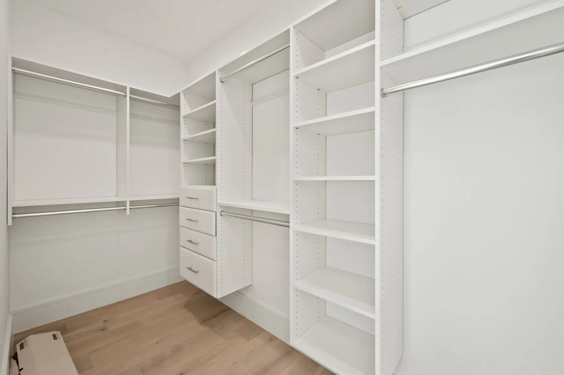 Walk-in closet with built-in shelves, drawers and hanging rods.
