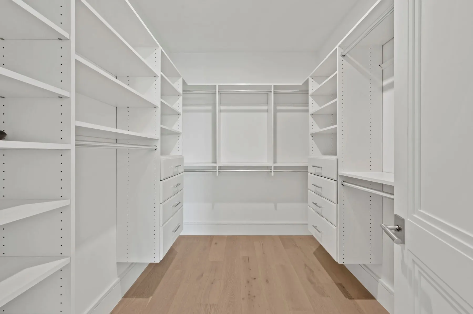 Walk-in closet with shelving on three walls.