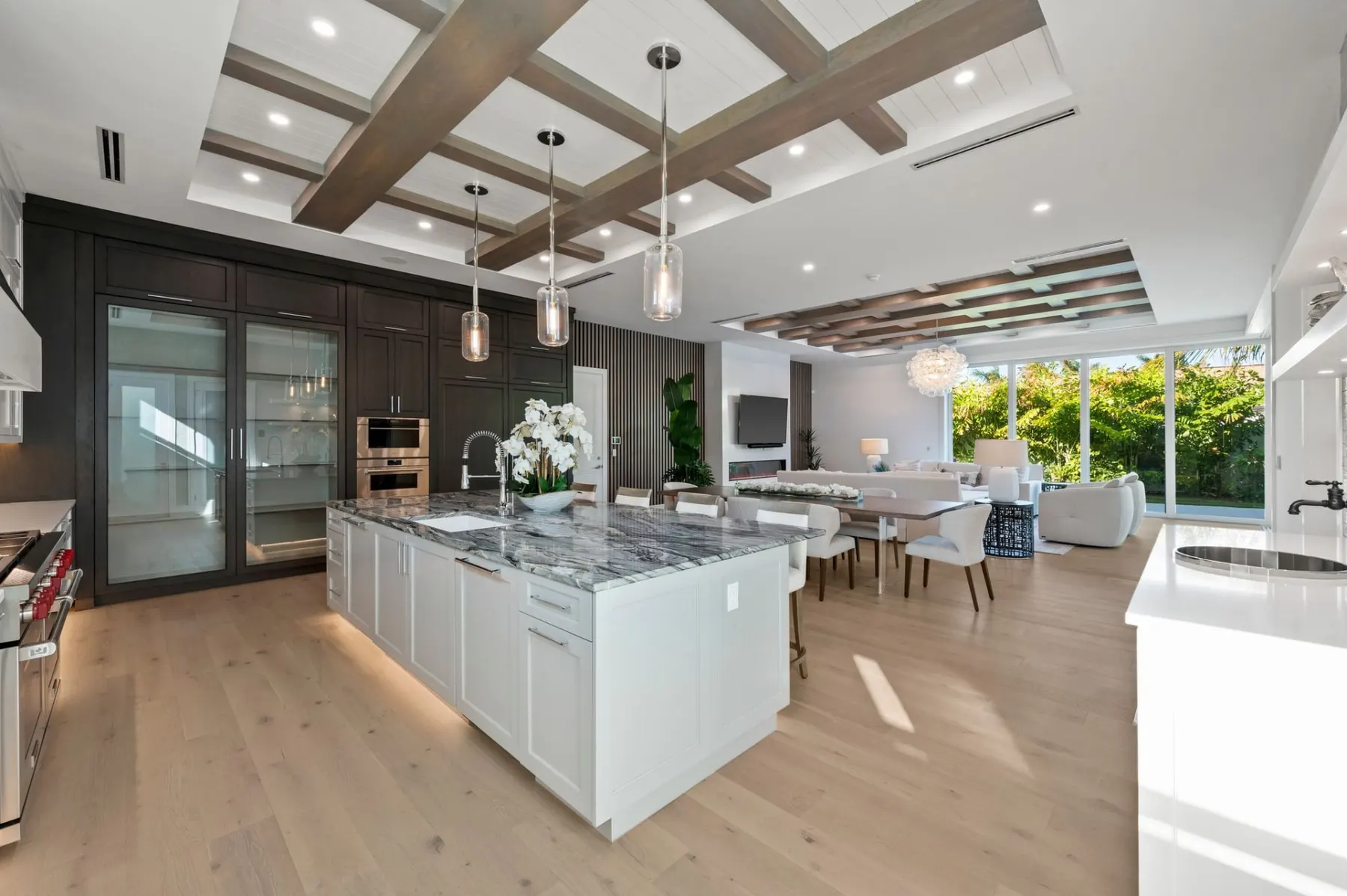 Kitchen island looking toward the dining table and living room, with floor-to-ceiling glass doors at the back.