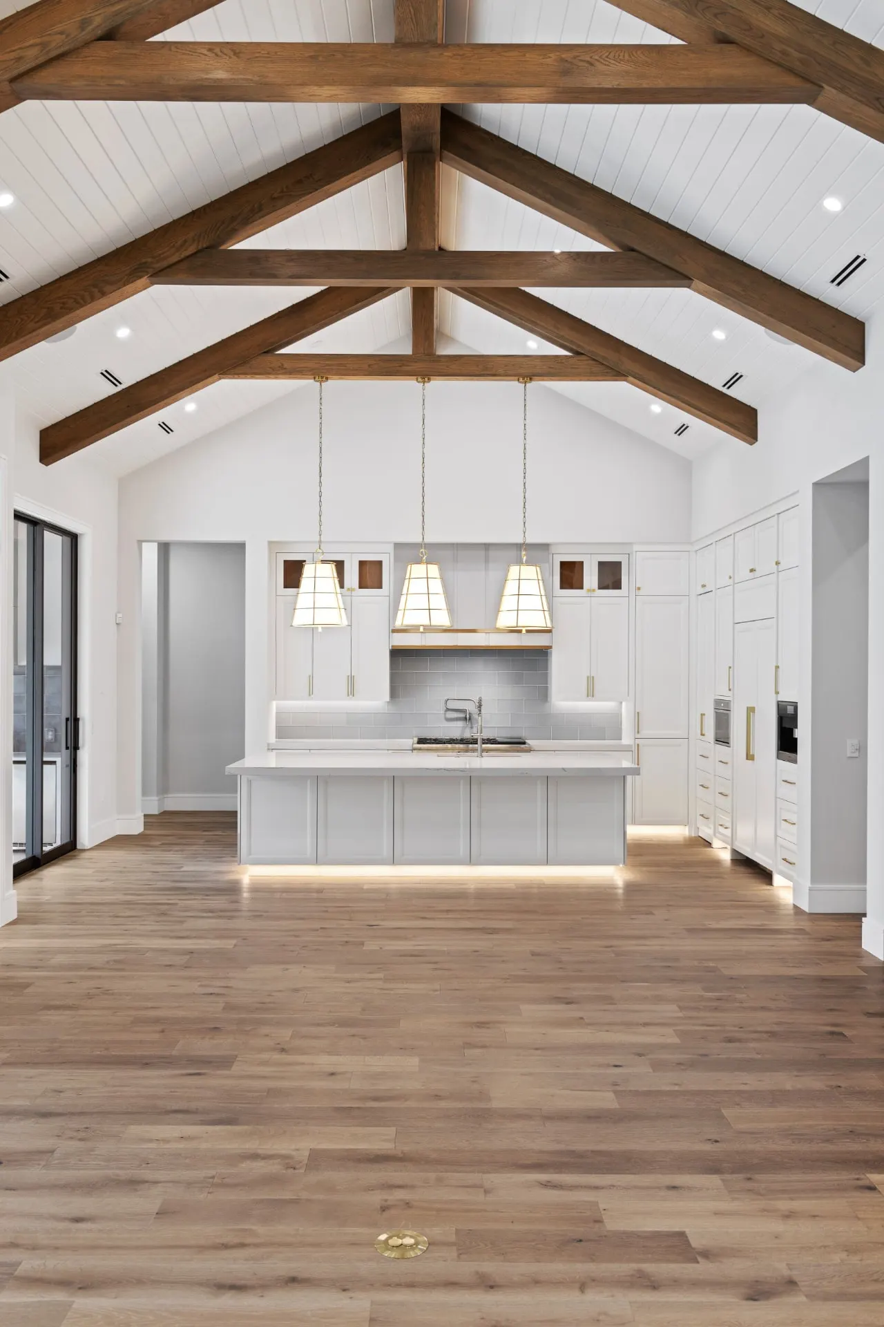 Portrait view of the great room trusses and the kitchen island beyond.
