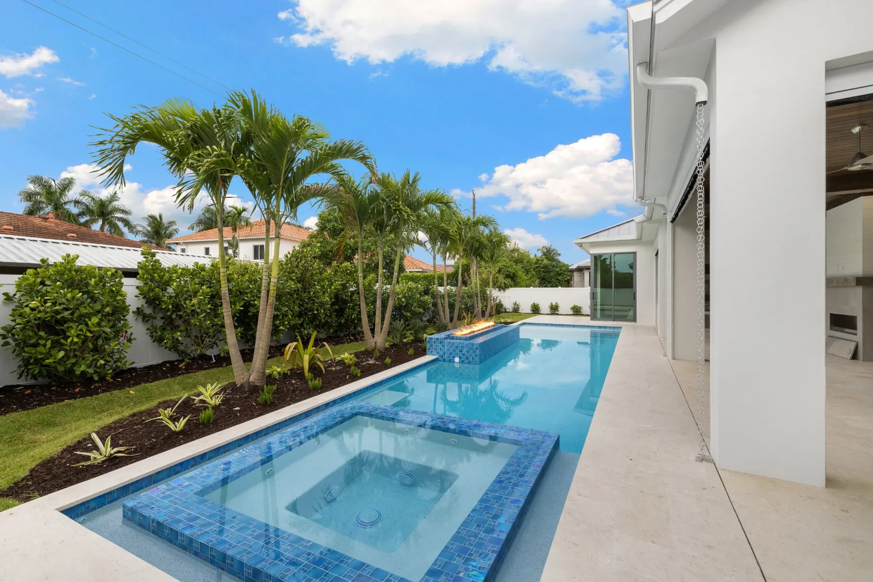 Spa and pool in daylight with the lanai and house at right.