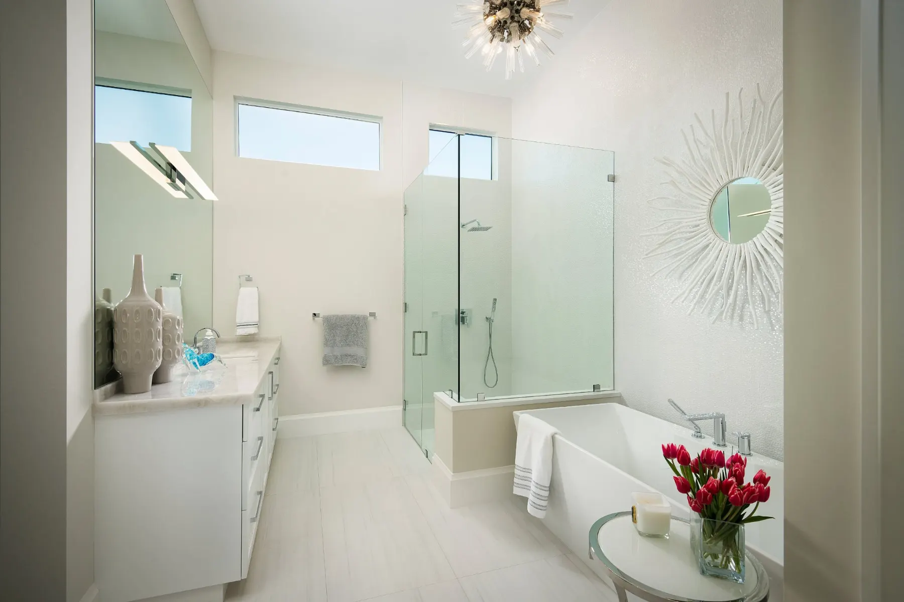 Primary bath with a double vanity, a glass-enclosed shower and a freestanding tub.